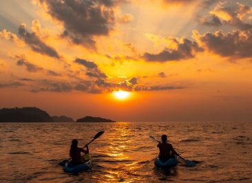 female-and-a-male-sailing-with-canoes-close-to-each-other-at-sunset-scaled